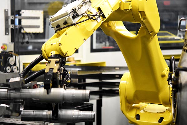 Yellow Robotic arm handling material in a factory